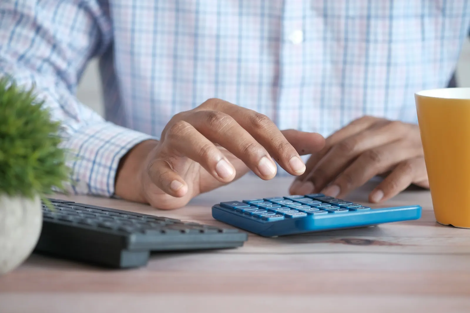 Mains sur une calculatrice et un clavier d’ordinateur