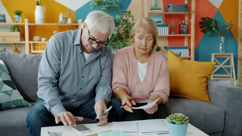 Couple examinant ses documents financiers à la maison